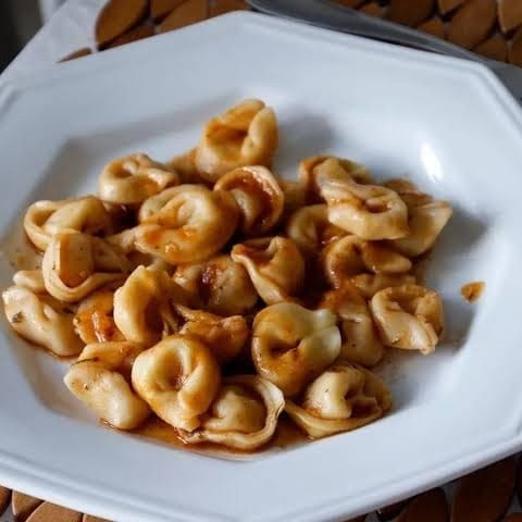 Apresentamos nosso delicioso Capeletti de Carne. Esta iguaria é cuidadosamente preparada com uma massa artesanal, envolvendo um suculento recheio de carne. Para completar, nosso molho de tomate refogado, adiciona um sabor autêntico e inesquecível. Finalizamos com queijo derretido. A combinação desses ingredientes resulta em uma textura e sabor incríveis, que encantam até os paladares mais exigentes. Desfrute desta experiência gastronômica única!