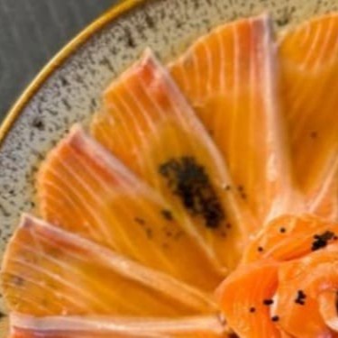 15 lâminas finas de barriga de salmão, finalizado com azeite trufado e flor de salmão.