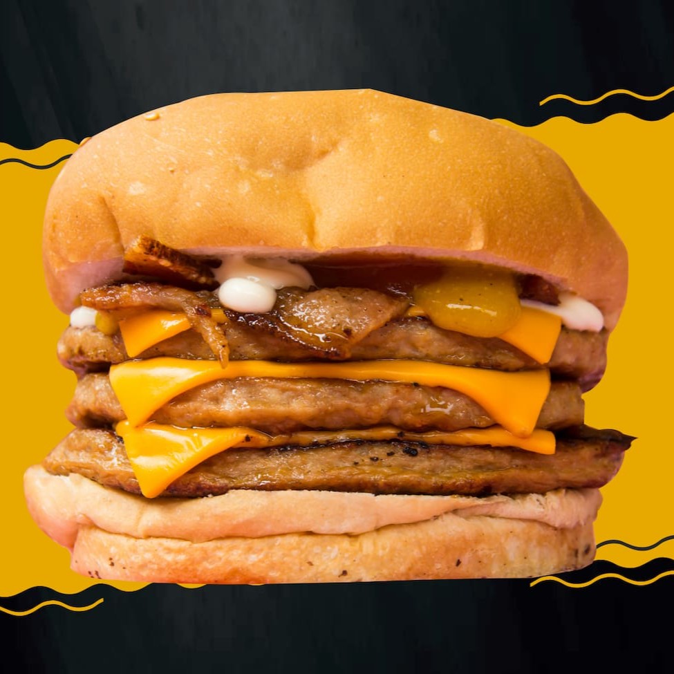 Pão com gergelim, 3 carnes, queijo cheddar, bacon, katchup, barbecue, mostarda e maionese temperada