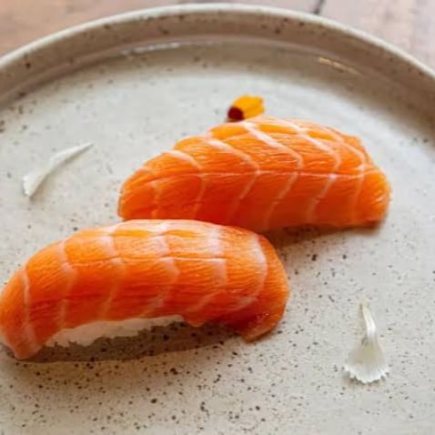 Niguiri de salmão é uma bolinha de arroz com neta de salmão cru por cima