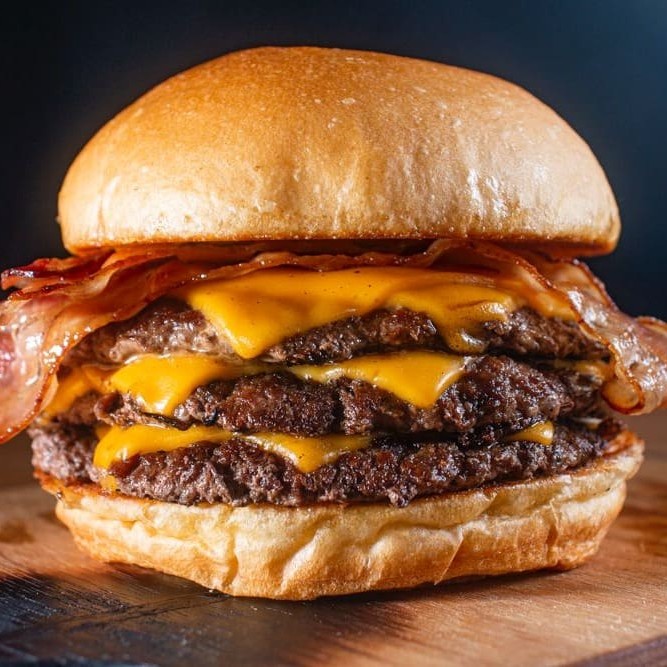 Um verdadeiro matador de fome:  Pão de brioche Três carnes de smash - 90g cada Queijo Cheddar Bacon fatiado Molho especial.