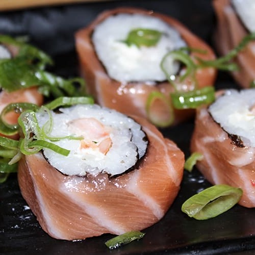 Enrolado de arroz, camarão, cream cheese, mix de cebolinha e alho poró, envolto com salmão.