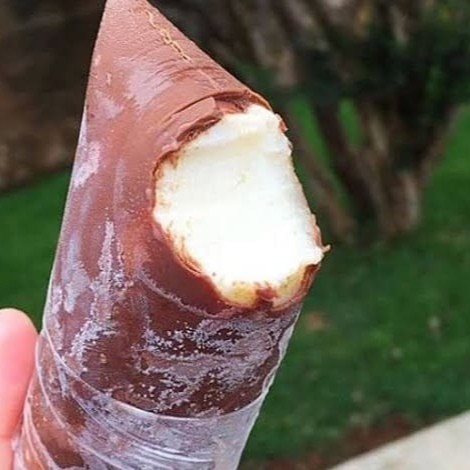 Um sorvete cremoso de coco, com sabor tropical intenso e textura suave, que captura a essência do coco fresco. A leveza refrescante do sorvete é perfeitamente complementada por uma casquinha crocante de chocolate, que oferece um contraste irresistível entre o toque doce e o frescor do coco e a rica camada de chocolate. A combinação harmoniosa entre a cremosidade do sorvete e a crocância do chocolate cria uma experiência deliciosa e sofisticada, ideal para quem busca uma sobremesa gourmet que lembra o consagrado doce.