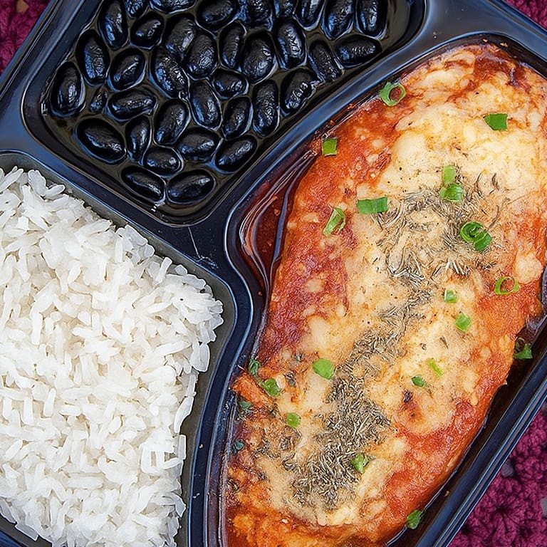 Marmita executiva individual (aprox. 550g): arroz branco soltinho, feijão de caldo grossinho e filé de frango à parmegiana com molho caseiro e queijo gratinado. Ideal pra matar a fome com sabor e praticidade! ️