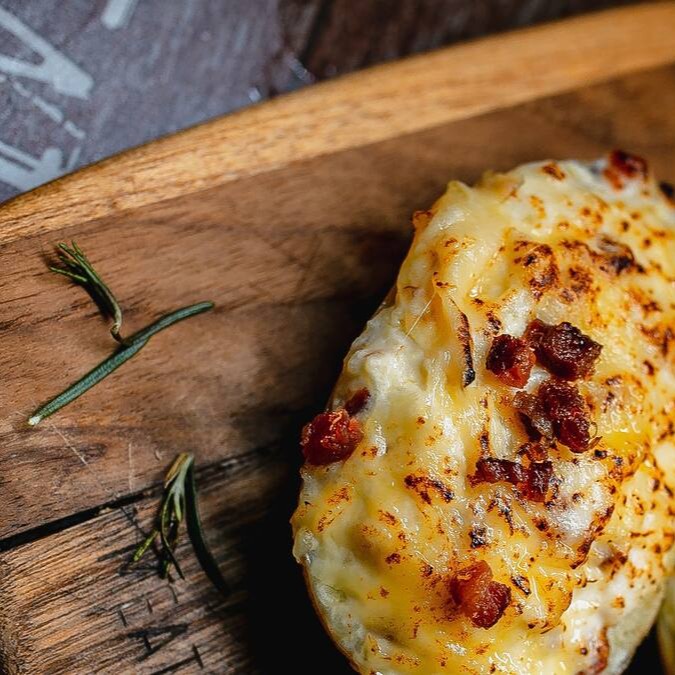 Meia Batata Inglesa recheada com saboroso Catupiry, coberta com cubinhos de bacon e um pouquinho de oregano