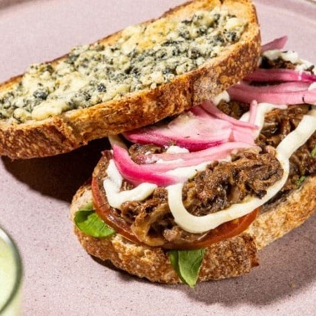 Um sanduíche poderoso: pão Sourdough e nossa suculenta costela braseada, complementada por picles de cebola, maionese da casa, tomate fresco, rúcula refrescante e queijo gorgonzola. Uma explosão de delícias, derrete na boca!