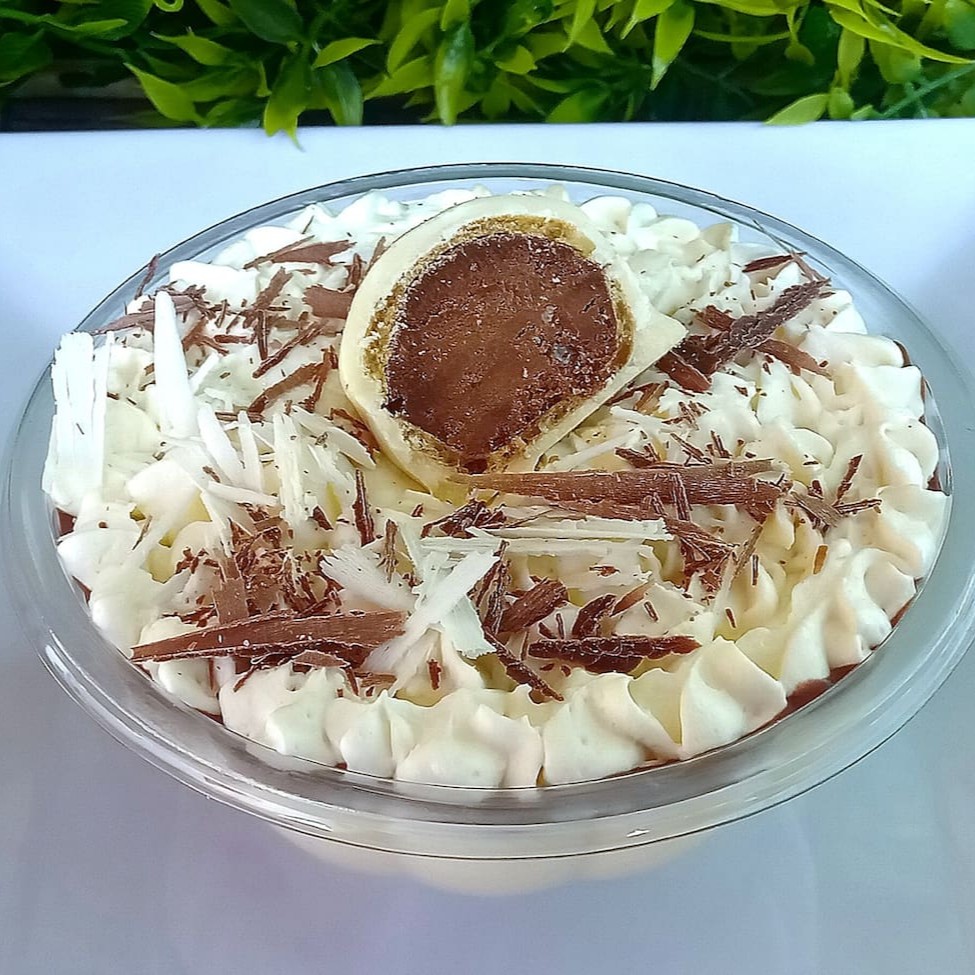 Creme branco cremoso, com bombom Ouro Branco picado, ganache de chocolate, coberto com chantilly trufado e finalizado com raspas de chocolate e bombom.