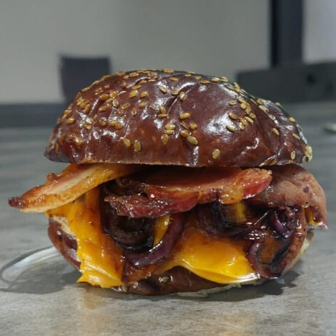 100g de blend angus especial com cebolas refogadas ao shoyu, tiras de bacon e creme de cheddar, no pão prime mais macio e delicioso do mundo!