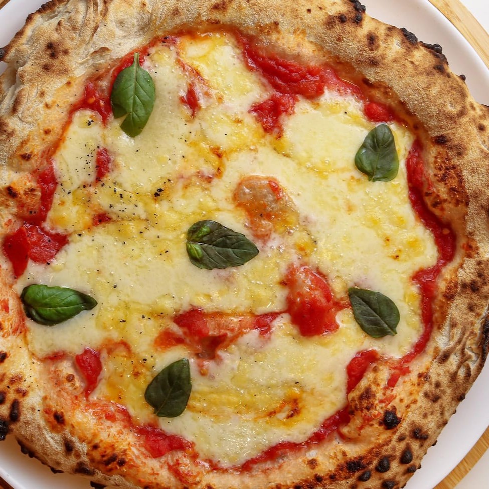 Pizza de longa fermentação com molho de tomate pelatti, muçarela de búfala, basílico e fio de azeite. Tamanho médio: 28 cm