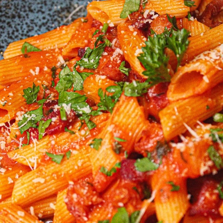Penne, bacon, vinho branco e molho de tomate.