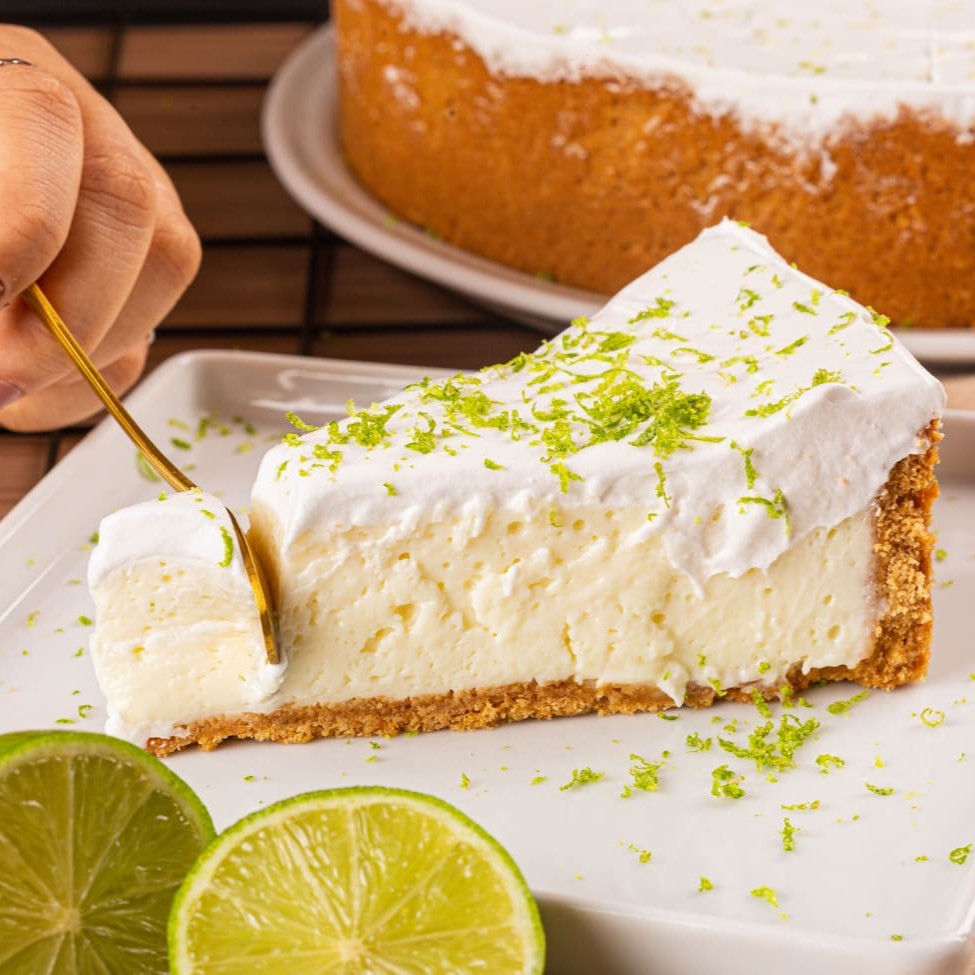 Delicie-se com a Torta Mousse de Limão. Cada mordida é um equilíbrio perfeito entre o azedinho do mousse de limão e o doce da massa de biscoito maizena, finalizada com chantilly e raspas de limão. É como uma explosão refrescante no paladar.