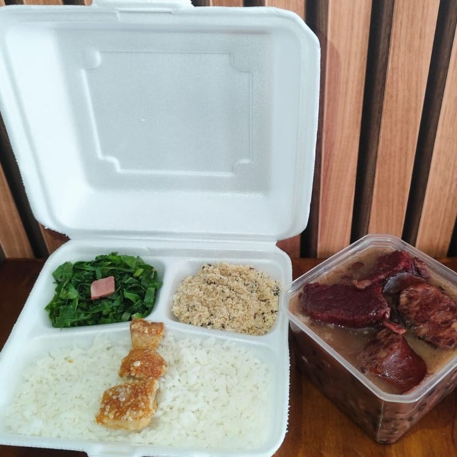 Feijoada completa com arroz branco, farofa da casa, couve manteiga refogada e torresmo crocante  com aproximadamente 1kg de comida. Nessa opção o pote de feijoada de 500ml vai separada das guarnições.