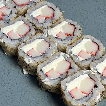 Uramaki de kani ( carne de caranguejo em bastão ) é um enrolado de arroz por fora e gergelim e recheado com kani creame chessee