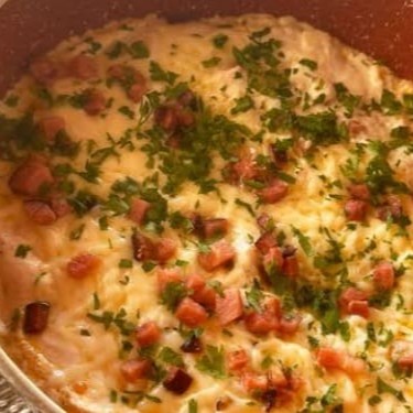 Macio e saboroso nhoque de aipim, servido com molho branco cremoso, frango desfiado e cubos de bacon dourados. Finalizado com cream cheese e salsinha fresca para um toque especial que derrete na boca. Uma explosão de sabor a cada garfada!