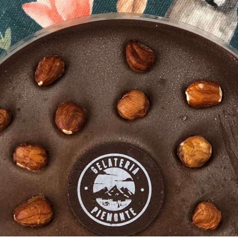 Experimente nossa tentadora Torta de Chocolate com Avelã. Desfrute do luxo de um sorvete de chocolate ricamente cremoso, delicadamente infundido com creme de avelã que proporciona um sabor marcante e sofisticado. A base é feita de irresistíveis biscoitos amanteigados crocantes que adicionam uma textura inigualável. Esta requintada torta italiana, com suas 12 generosas fatias, é a sobremesa perfeita para compartilhar em ocasiões especiais ou simplesmente para indulgir-se em um momento de puro prazer. Uma verdadeira obra-prima da categoria 'Tortas de Gelato Italiano'.