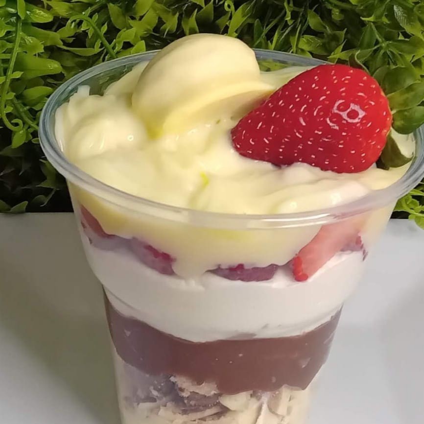 Recheio de chocolate branco, pedaços de bombom Ouro Branco, recheio de chocolate, mousse de leite Ninho, morangos e finalizado com bombom e morango.