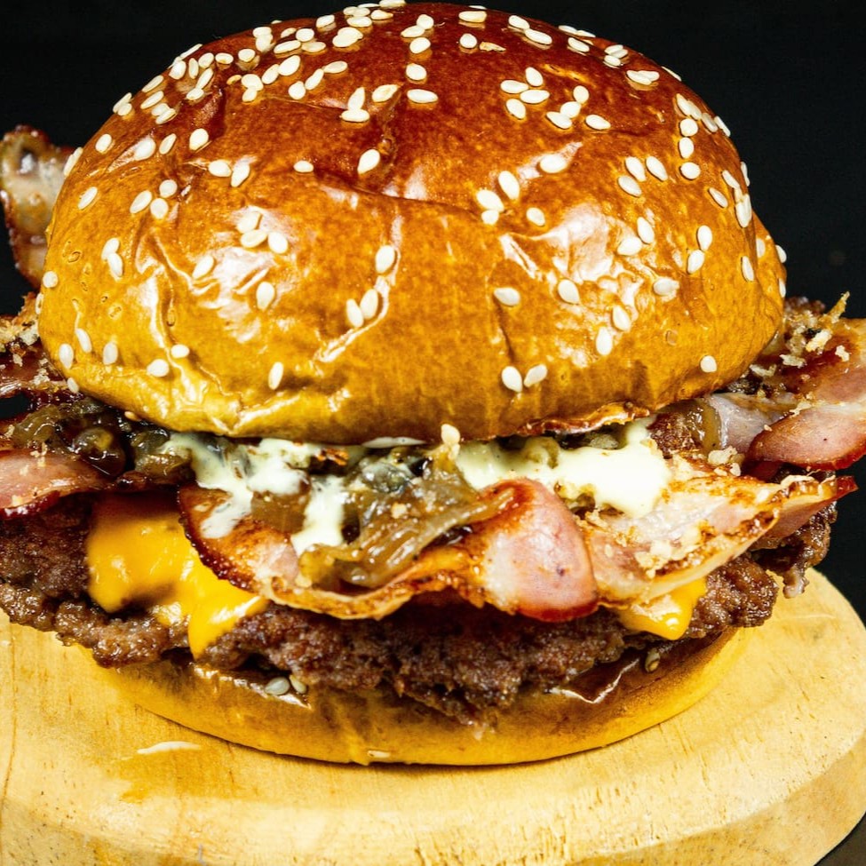 "Nosso suculento ""bacon é vida"" composto de dois deliciosos smash de 80gr, temepero secreto da casa, queijo, uma crocante farofa de bacon feita artesanalmente, deliciosas tiras de bacon crocante e maionese da casa."