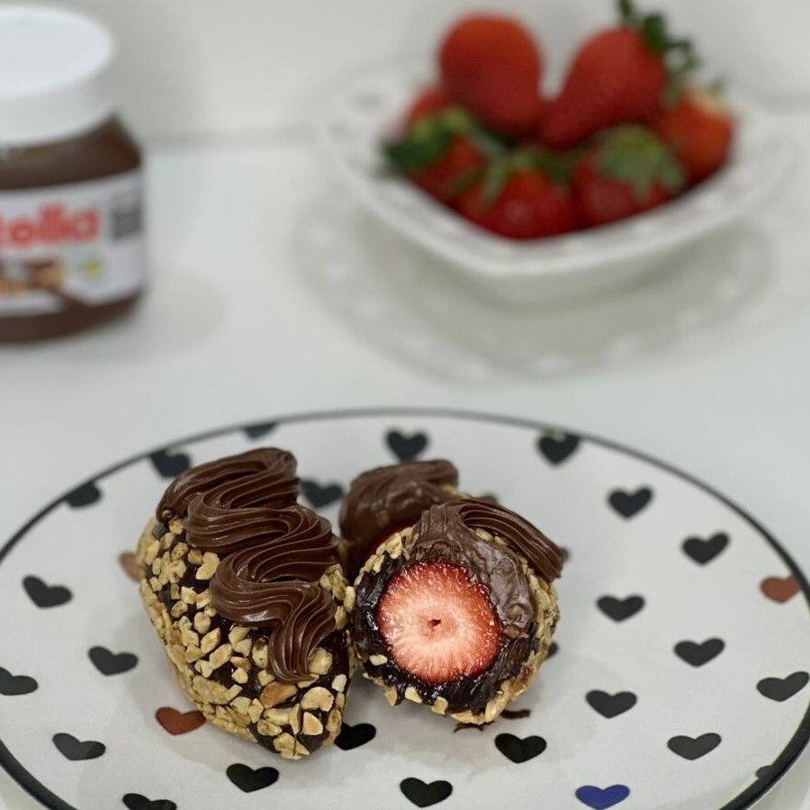 Morangos frescos envolvido em um brigadeiro cremoso, envoltos em amendoim e finalizados com Nutella. Uma explosão irresistível de sabor e textura em cada mordida!