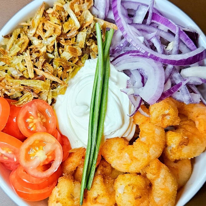 Arroz, cream cheese, camarão empanado, cebola roxa, tomate cereja e alho poro.