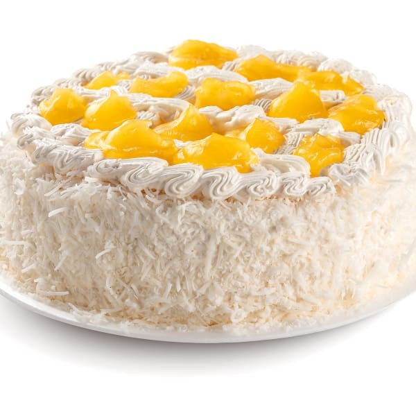 Bolo branco recheado com creme de coco com pedaços de abacaxi, coberto com chantilly e decorado com abacaxi e coco.