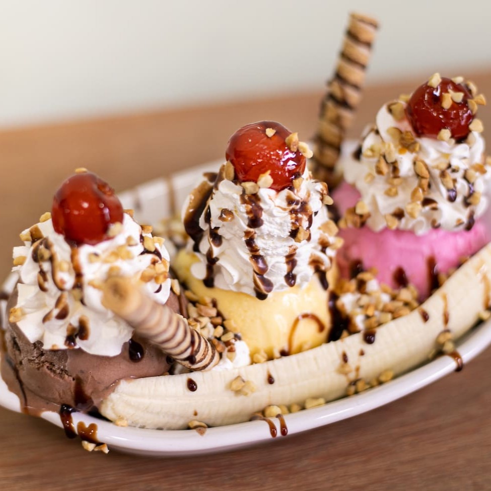 Banana, 3 bolas de sorvete, chantilly, cobertura, complemento e biscoito tubette. Vai em embalagem térmica e complementos separados.