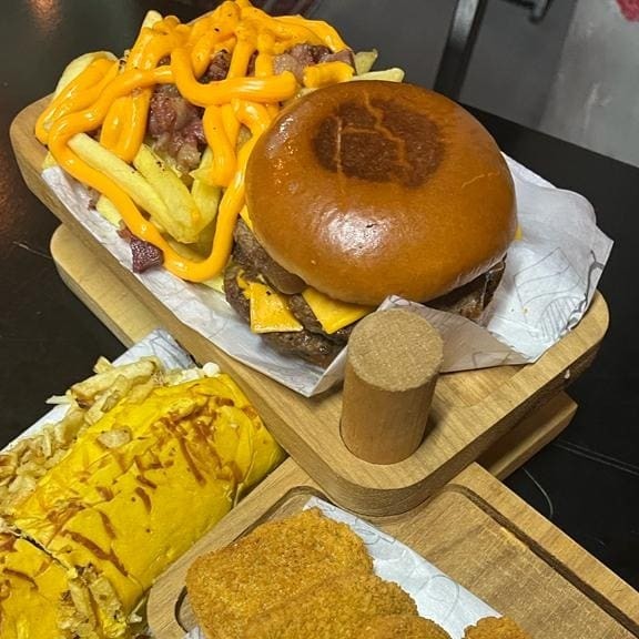 1 Smash Duplo( Pão Brioche Macio, 90g De Carne Artesanal, Cheddar Cebola Caramelada E Molho Especial), 1 Gross Jean (Salsicha Ou Linguiça) 5 Anéis De Cebola Deliciosos, 5 Nuggts Porção De Batata Frita Com Cheddar Cremoso, Bacon Em Cubos E Molho Especial Lanche serve 2 pessoas
