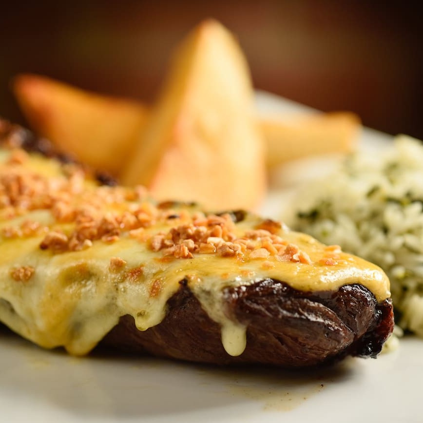 Suculenta picanha gratinada, coberta de mix de queijos e alho. Acompanha batata homemade e arroz de brócolis.