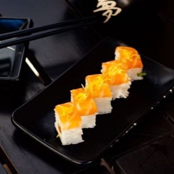 Arroz, salmão creem cheese e cebolinha, com uma lasca de salmão e raspa de limão siciliano  por cima