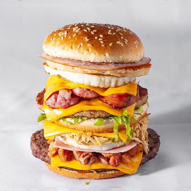 Pão, Alface, Ketchup, Maionese, 4 Carnes, 4 Fatias de Queijo Cheddar, 4 Ovos, Bacon e Calabresa