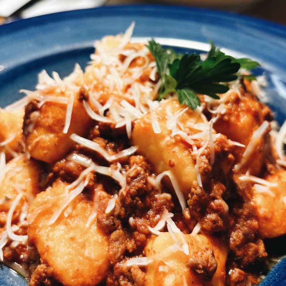 Experimente o nosso Gnocchi Artesanal al Ragu de Bolonhesa, uma delícia feita com massa de gnocchi fresca e macia, coberta por um ragu de bolonhesa saboroso e lentamente cozido. Cada garfada traz o equilíbrio perfeito entre a suavidade do gnocchi e o sabor robusto da carne, enriquecido com temperos especiais e ingredientes italianos. Uma explosão de sabores que vai aquecer o seu paladar!