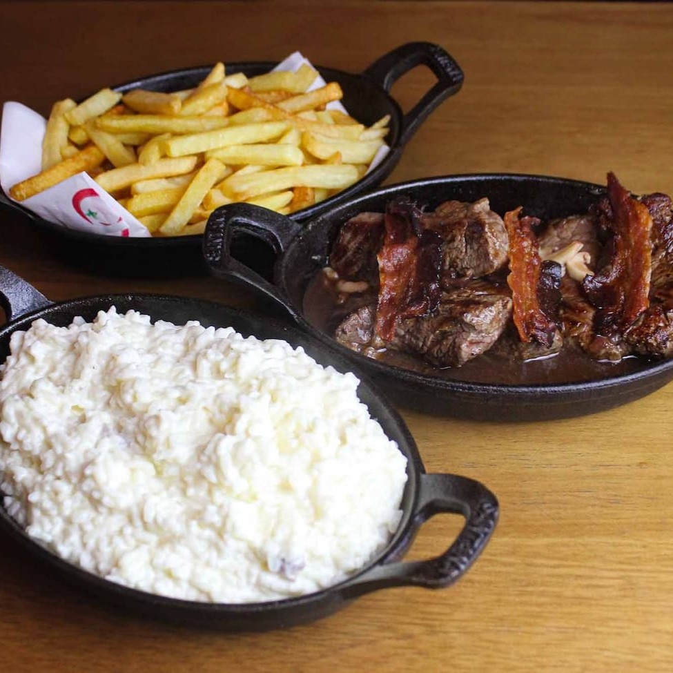 Medalão de filé mignon ao molho madeira, bacon, arroz à piamontese e batata frita.