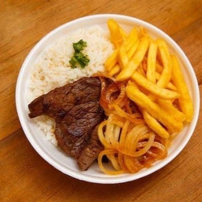 Perfeito para os amantes de uma boa carne, nosso 'Bife com Fritas', um dos mais pedidos, é irresistivelmente delicioso. A suculência do bife acebolado, preparado com maestria, se une ao sabor caseiro do arroz e feijão para uma refeição familiar autêntica. Acompanha fritas crocantes, douradas à perfeição, que trazem uma textura incrível para o prato. É a combinação perfeita para quem busca conforto e sabor em uma só refeição.