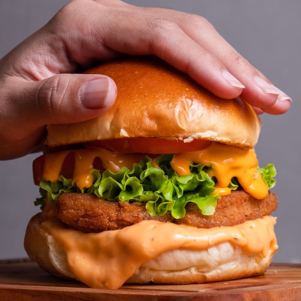 "•  No pão brioche,  peito de frango empanado, queijo cheddar, alface, tomate,  2 fatias de bacon e molho billy, Ponto da casa:""ao ponto p/mal"". Caso desejar sua carne em outro ponto, por favor especificar na observação.  Foto ilustrativa."