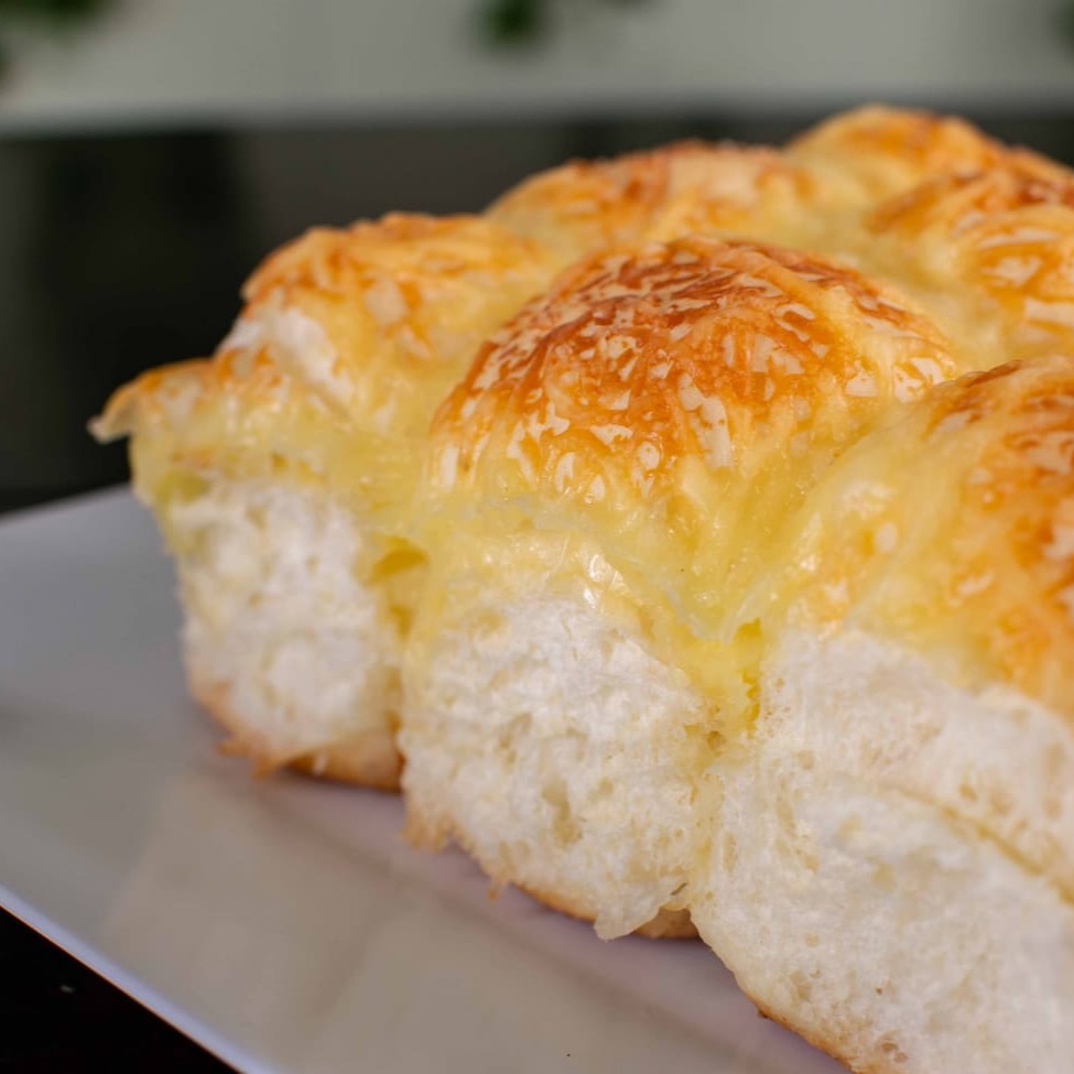 Pão brioche coberto com queijo parmesão