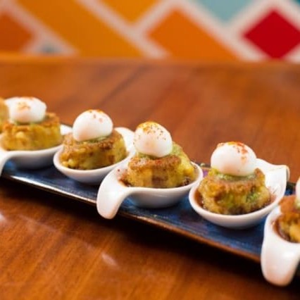 Bolinho de batata com especiarias - bolinho de batata condimentada com chutney de tâmaras e hortelã e uma esfera de iogurte no topo