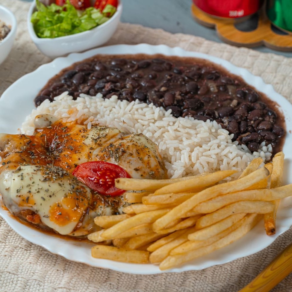 Filé de frango suculento, empanado e coberto com um irresistível molho de tomate caseiro e queijo derretido. Acompanha arroz soltinho, feijão bem temperado, batatas fritas douradinhas, farofa crocante e uma salada fresquinha. Uma combinação perfeita de crocância, cremosidade e muito sabor!