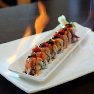 Enrolado  com arroz invertido, cebolinha, creme cheese e camarão, com envolto de salmão selado e molho de pimenta.