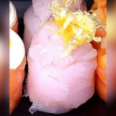 Enrolado de peixe branco e arroz, com cream cheese, finalizado com tartar de peixe branco e raspas de limão siciliano
