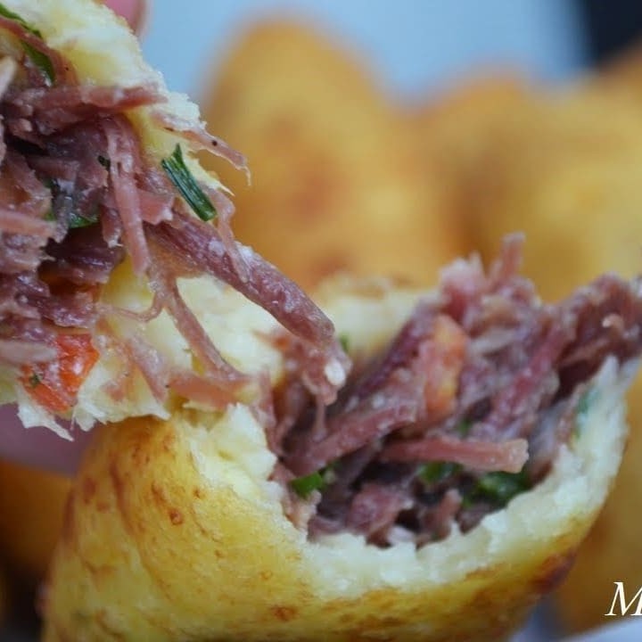 Apresentamos nosso delicioso e autêntico 'Bolinho de Aipim com Carne Seca'. Este deleite, cuidadosamente preparado em nossa cozinha, é uma maravilhosa demonstração da culinária caseira. O aipim, selecionado com critério, é transformado em um bolinho perfeitamente dourado e crocante. O recheio é uma generosa porção de carne seca, bem temperada e desfiada, que proporciona um contraste de sabores que irá surpreender seu paladar. Este prato, da categoria 'Salgados Fritos', promete ser um verdadeiro deleite para os apreciadores da culinária de boteco. Não deixe de experimentar!