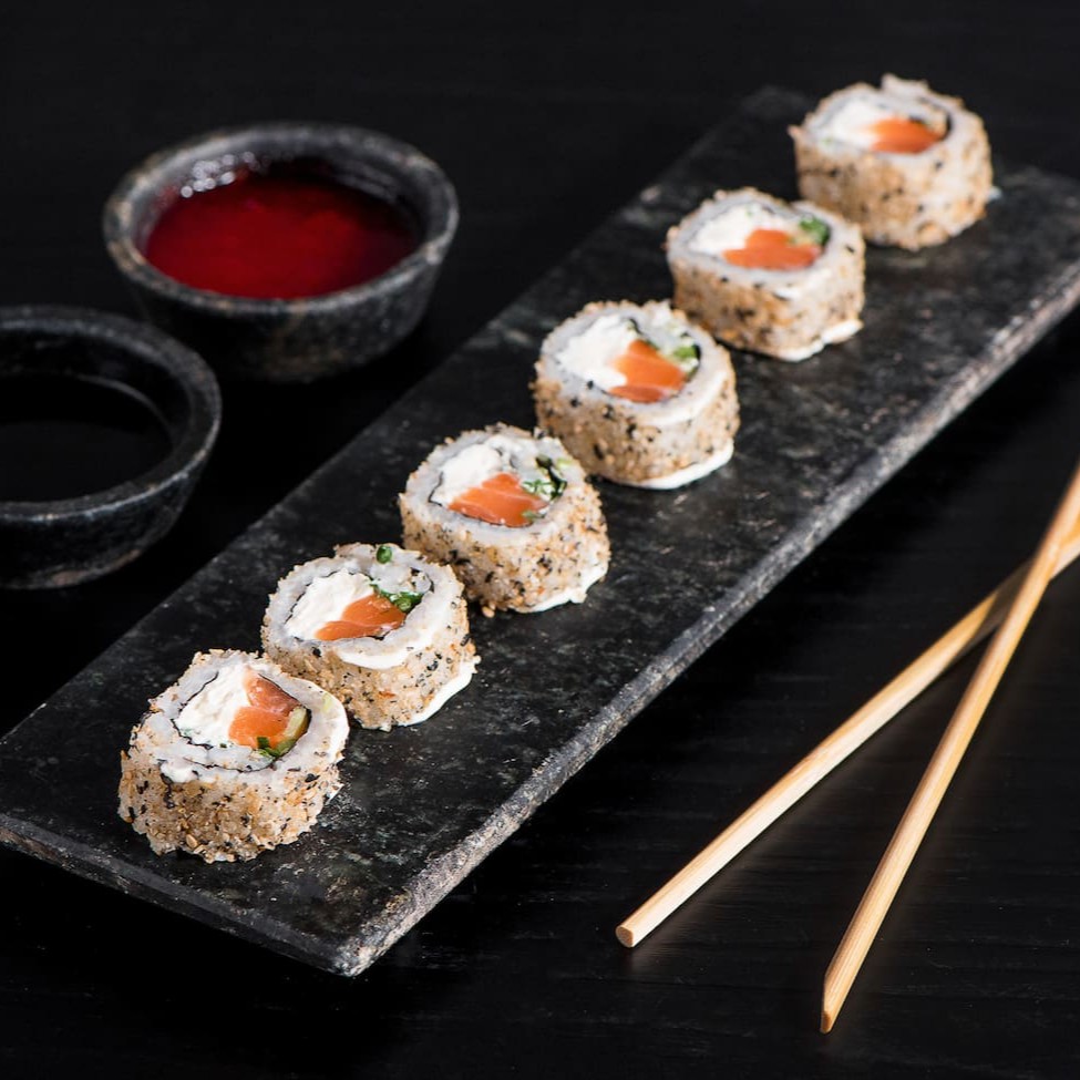 Arroz e gergelim com algo por dentro, recheado com salmão, cream cheese e cebolinha.