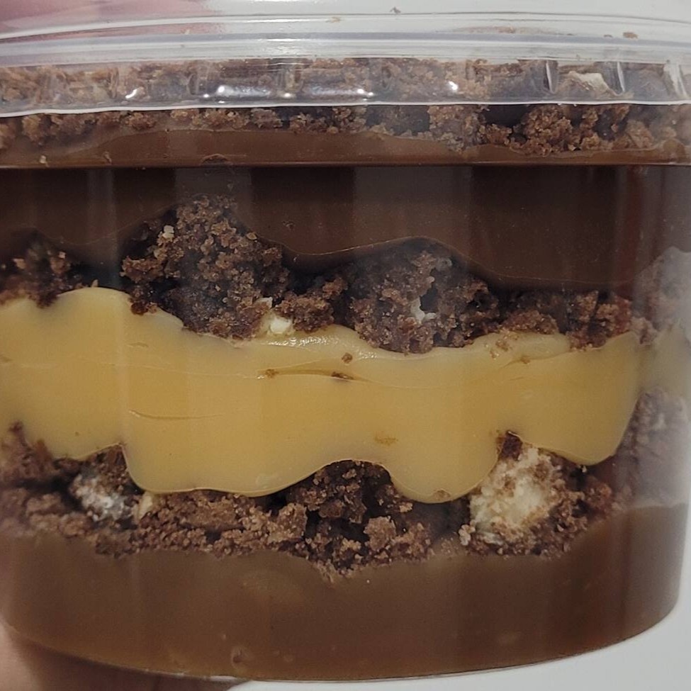 Camadas dos nossos brigadeiros cremoso ao leite, branco e meio amargo e pedaços do nosso cookie triplo chocolate com massa de cacau e gotas de chocolate ao leite e branco