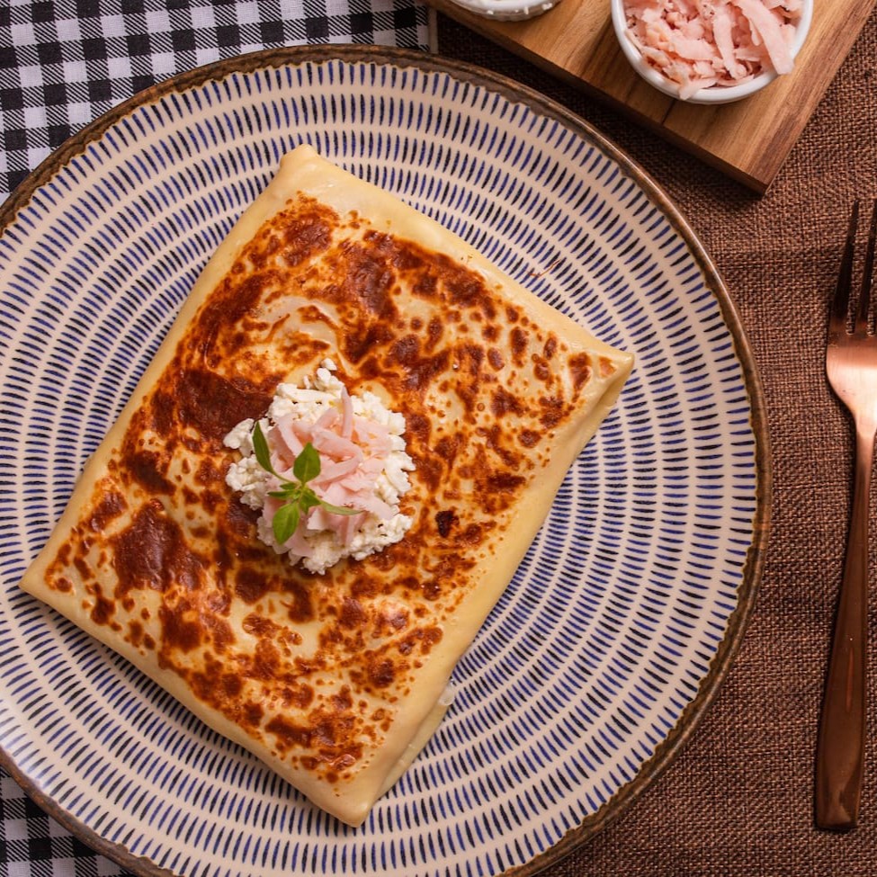 Delicioso crepe recheado com creme de queijo, alho poró e peito de peru