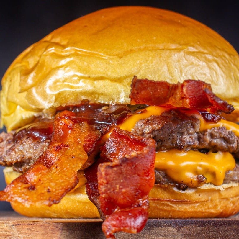 Quanto Mais Bacon, Melhor! Delicioso pão brioche selado, Dois blend 110g com queijo cheddar derretido no vapor, dupla camada de bacon crocante, cebola caramelizada e barbecue