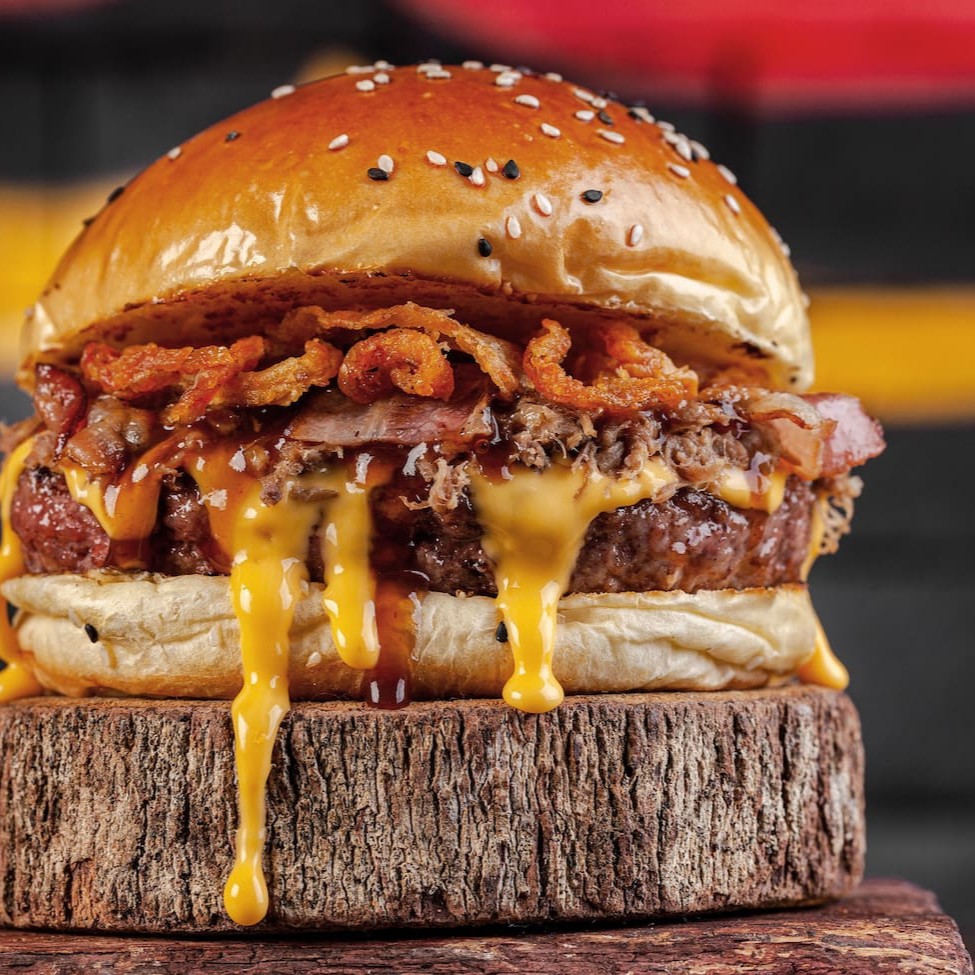 Experimente a incrível versão atualizada do 'Fire Crispy', este burger traz um delicioso pão brioche salpicado de gergelim, acolhendo um blend suculento de 160g com seleta gordura angus. Acrescentamos um creme de cheddar exclusivo, receita secreta do nosso chef. A costela bovina meticulosamente desfiada e o bacon fatiado adicionam uma nota defumada e intensa. Finalizando esta obra-prima, a cebola crispy oferece um toque crocante e saboroso. Prepare-se para uma explosão de sabores!