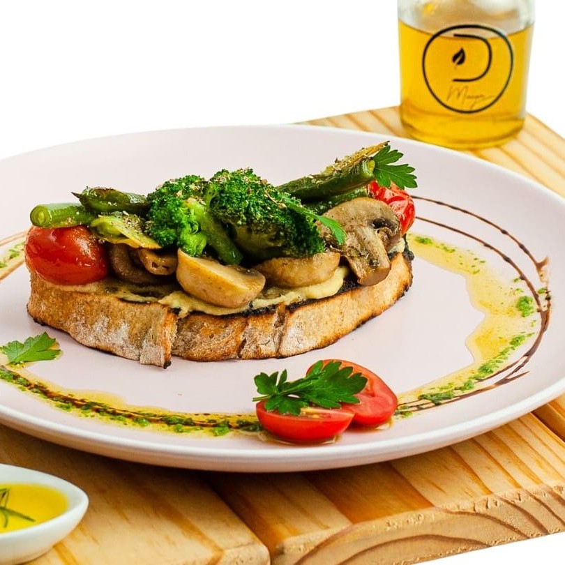 Brusqueta vegetariana com hummus feito na casa e mix de cogumelos.