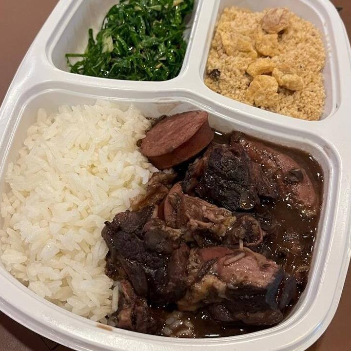 Feijoada individual com linguça  carnes diversas salgadas acompanha arroz branco , couve ao alho e farofa .