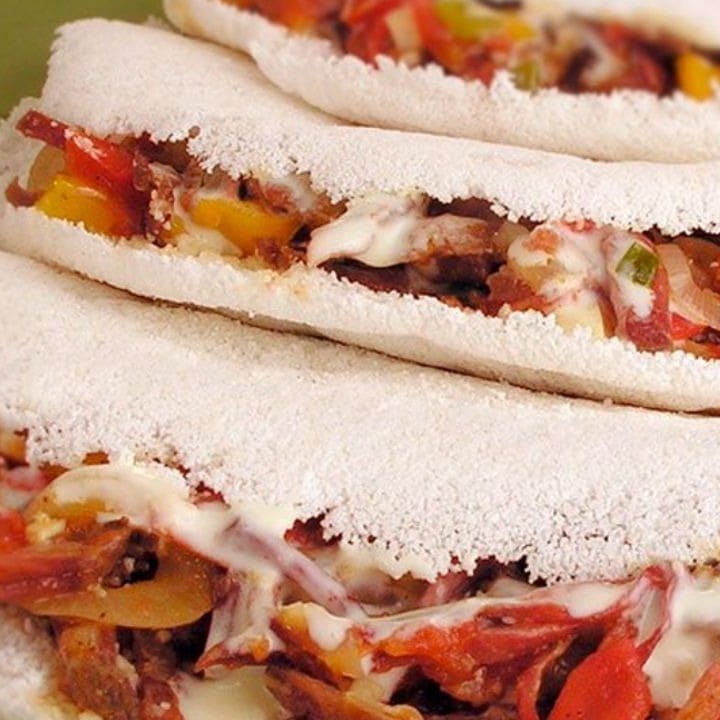 Inspirada no tradicional sabor da pizza portuguesa, essa tapioca é recheada com mussarela derretida, presunto, calabresa em rodelas, bacon crocante, milho, azeitonas, ovo, cebola, tomate e orégano. Finalizada com manteiga de garrafa, que realça todos os sabores e confere um toque especial. Uma combinação rica, suculenta e cheia de personalidade, perfeita para quem busca uma experiência completa e saborosa.