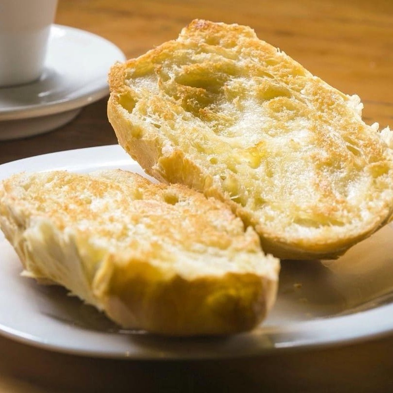 O clássico do café da manhã! Pão francês na chapa, dourado e crocante por fora, macio por dentro e com aquele sabor amanteigado que a gente ama.  Preparado na hora, com manteiga derretendo sobre o pão quentinho — simples, delicioso e impossível de resistir.  • Ingredientes principais: pão francês fresco e manteiga. • Diferencial: pão assado diariamente e prensado na hora, garantindo crocância e sabor autêntico. • Alergênicos: contém glúten e derivados de leite.