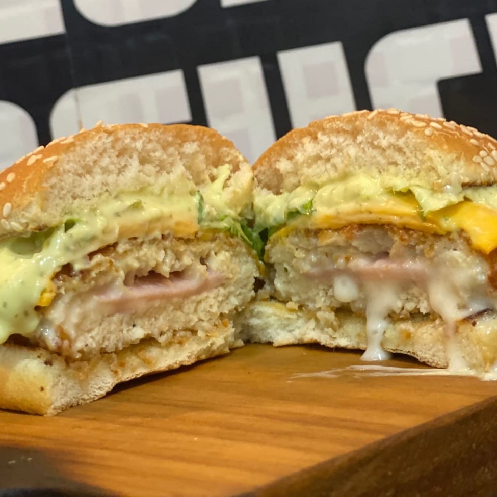 Pão, frango empanado com queijo e presunto, molho e salada