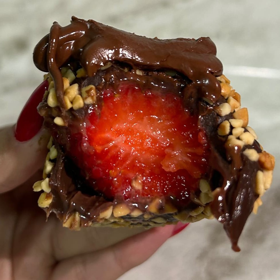 Docinho de brigadeiro com morango, coberta com amendoim e Nutella